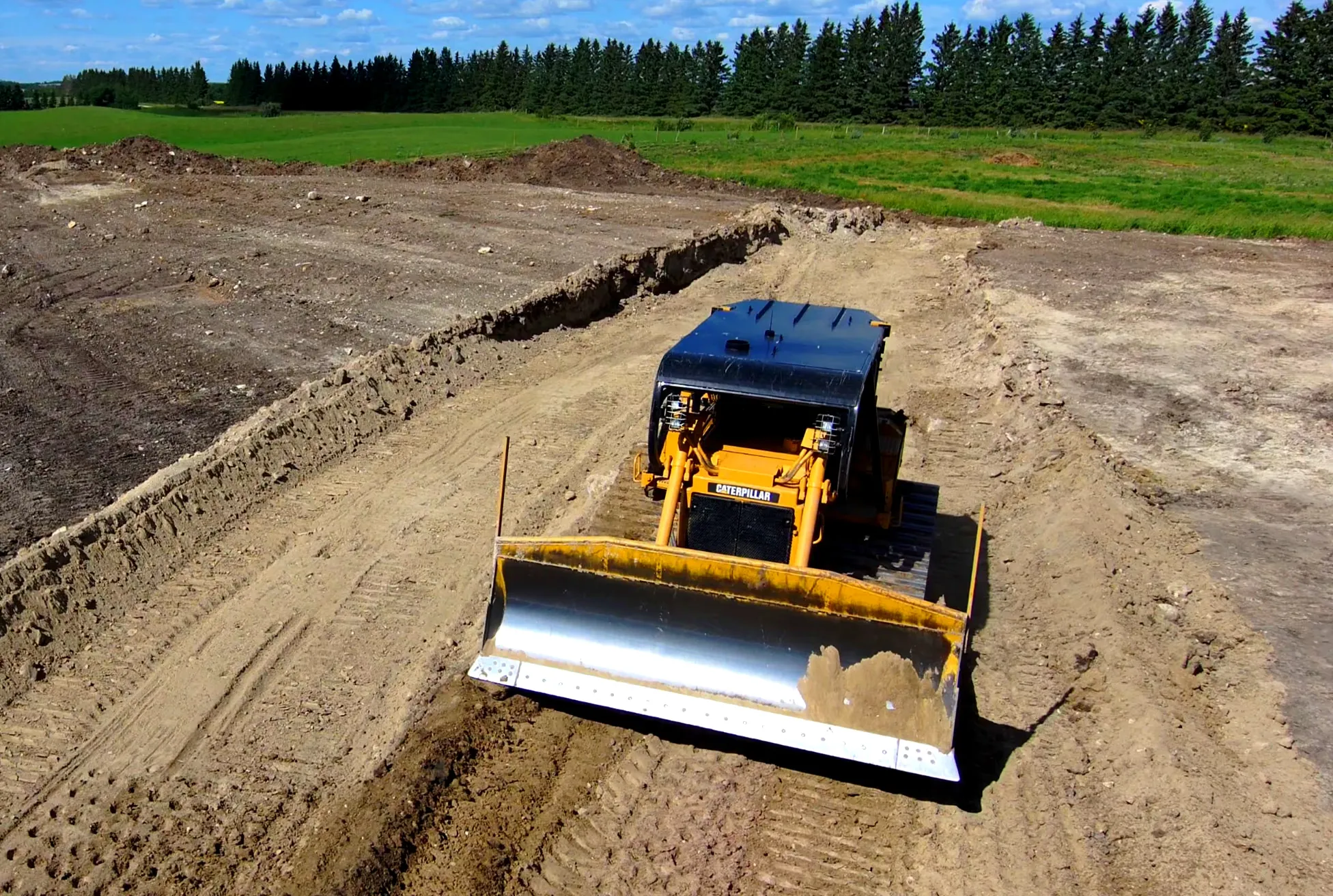Caterpillar D6 dozer with a clean blade ready to work a job site for Hard Work Industries